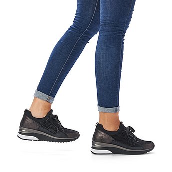 Schwarze Halbschuhe aus Lederimitat und Stretchmaterial mit Wechselfußbett. Schuhe am Fuß.
