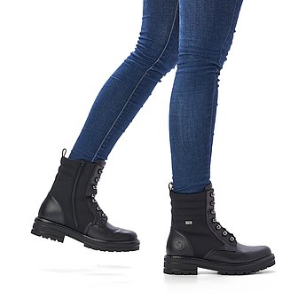 Schwarze Stiefeletten leicht wärmend aus Glattleder und Textil mit Reißverschluss, wasserabweisendem Remonte TEX und Wechselfußbett. Schuhe am Fuß.