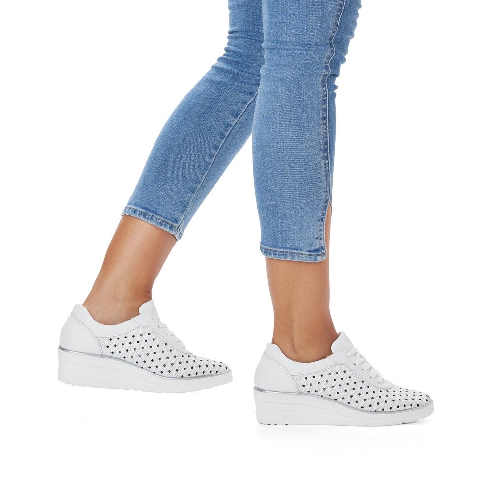 White remonte women´s sneakers R7217-80 with a lacing and perforated look. Shoe on foot.
