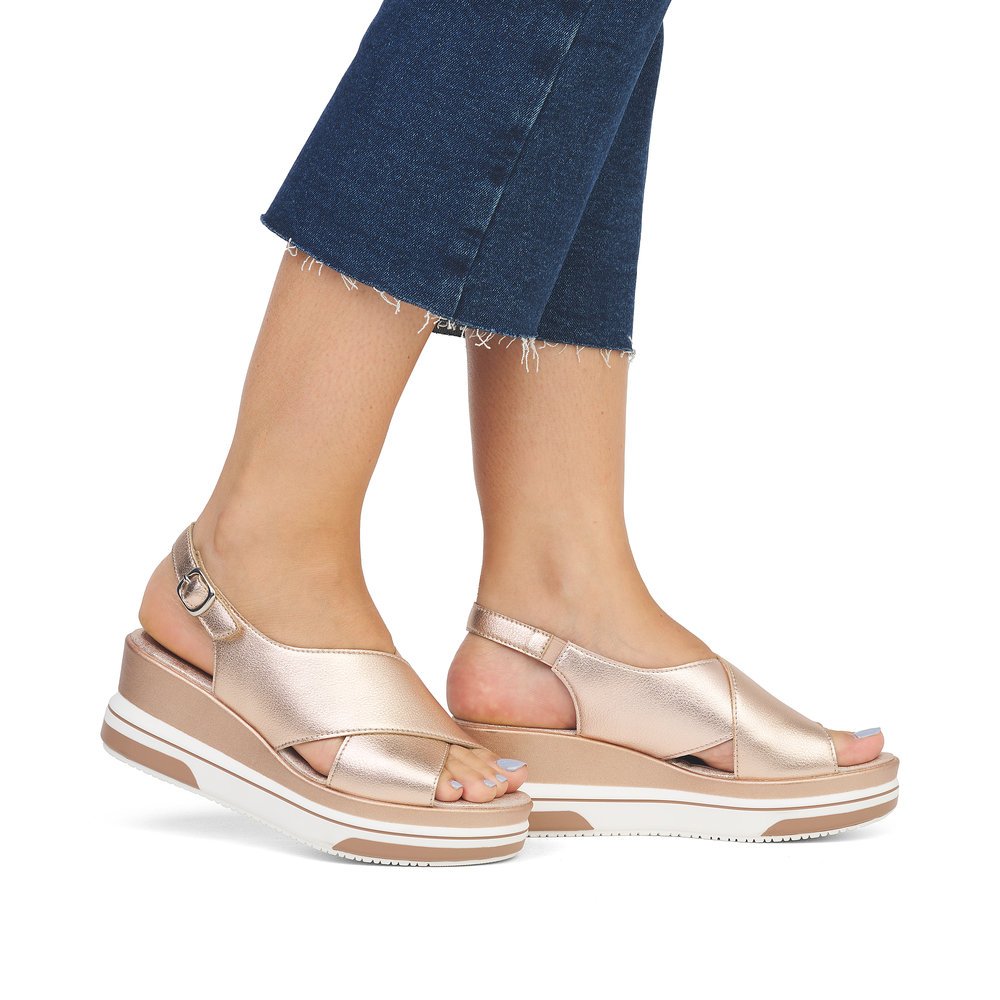 Metallic pink remonte women´s wedge sandals D1P53-31 with hook and loop fastener. Shoe on foot.