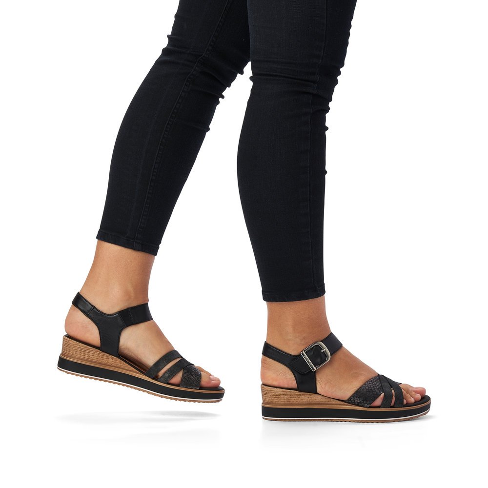 Jet black remonte women´s wedge sandals D6454-00 with a hook and loop fastener. Shoe on foot.