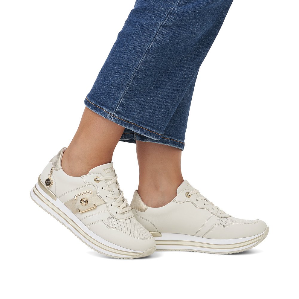Beige remonte Damen Sneaker D1322-60 mit einer Schnürung sowie Metallelement. Schuh am Fuß.