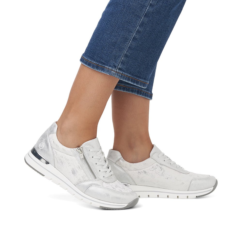 Silberne remonte Damen Sneaker R6700-91 mit einem Reißverschluss. Schuh am Fuß.