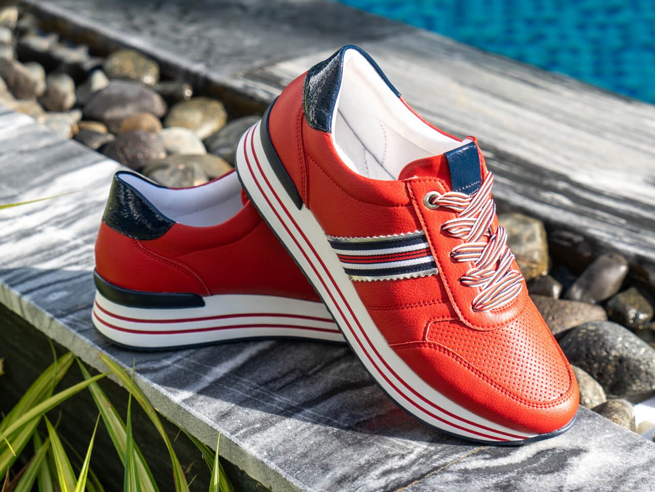 Rote Damen Sneaker von Remonte im maritimen Design und blau-weiß-roten Schnürsenkeln.
