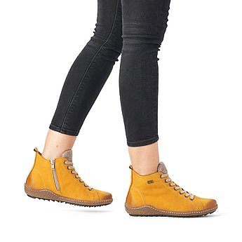 Gelbe Stiefeletten aus Rauhleder mit Reißverschluss und Schnürung, wasserabweisendem Remonte TEX und Wechselfußbett. Schuhe am Fuß.