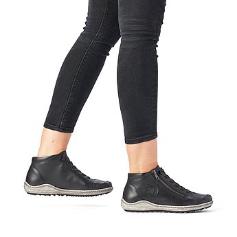Schwarze Kurzstiefel aus Glattleder mit Reißverschluss und Schnürung und Wechselfußbett. Schuhe am Fuß.