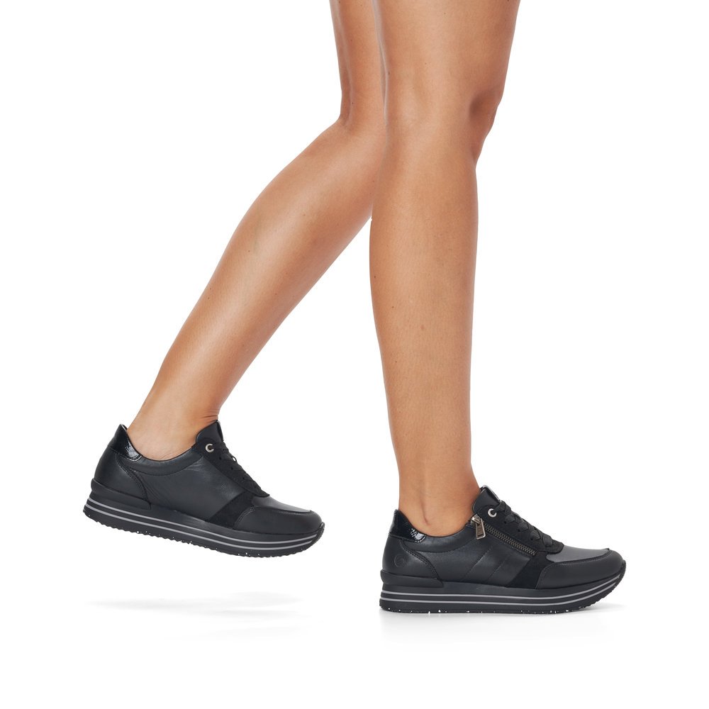 Schwarze remonte Damen Sneaker D1316-02 mit Reißverschluss sowie Komfortweite G. Schuh am Fuß.