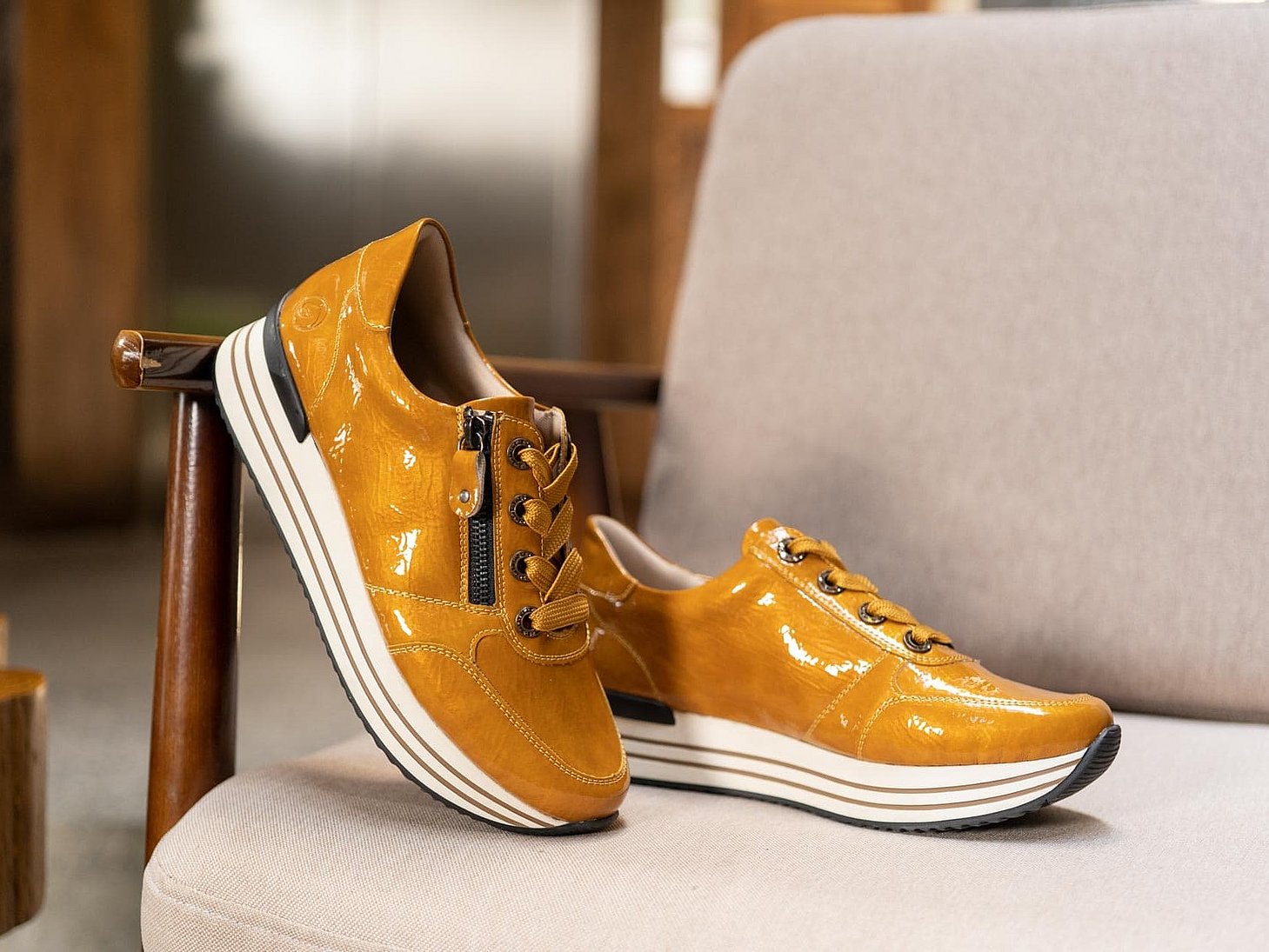 Gelbe Sneaker aus Kunstlack mit Reißverschluss und Schnürung und Wechselfußbett.