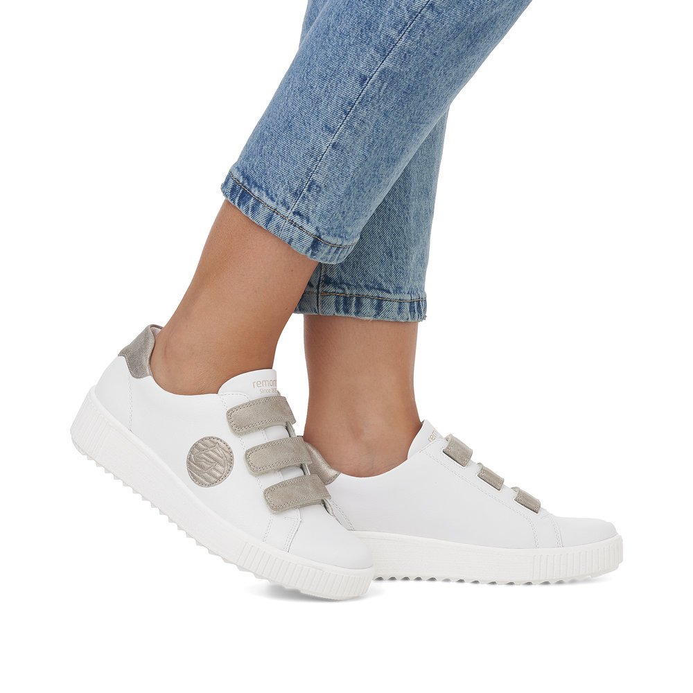 White remonte women´s sneakers R7902-80 with a hook and loop fastener and grey logo. Shoe on foot.