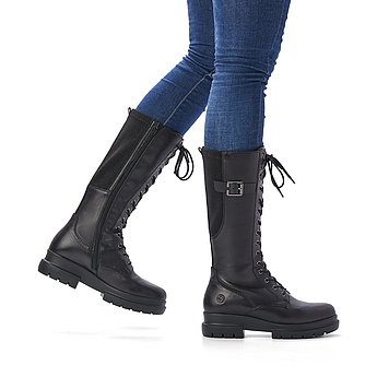 Schwarze Stiefel warm gefüttert aus Glattleder mit Reißverschluss und Schnürung, Stretch-Einsatz im Wadenbereich und Wechselfußbett. Schuhe am Fuß.