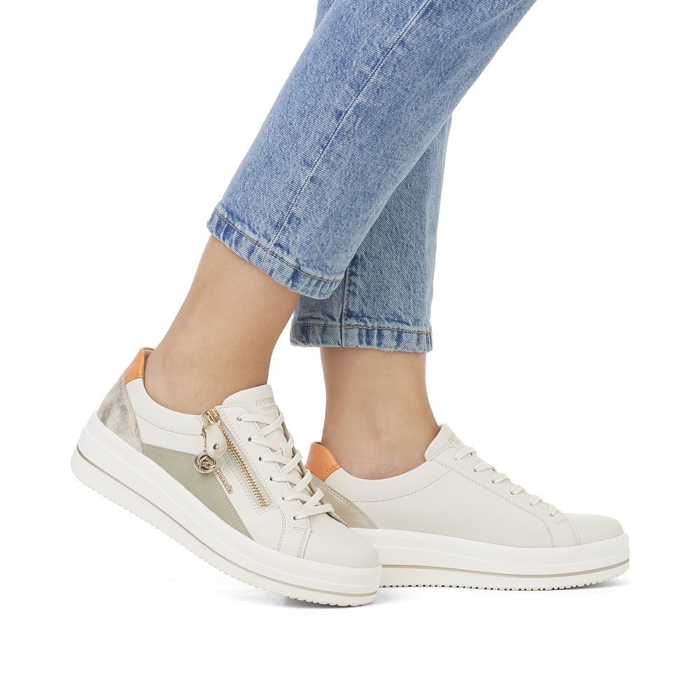 Weiße remonte Damen Sneaker D1C01-81 mit Reißverschluss sowie der Komfortweite G. Schuh am Fuß.