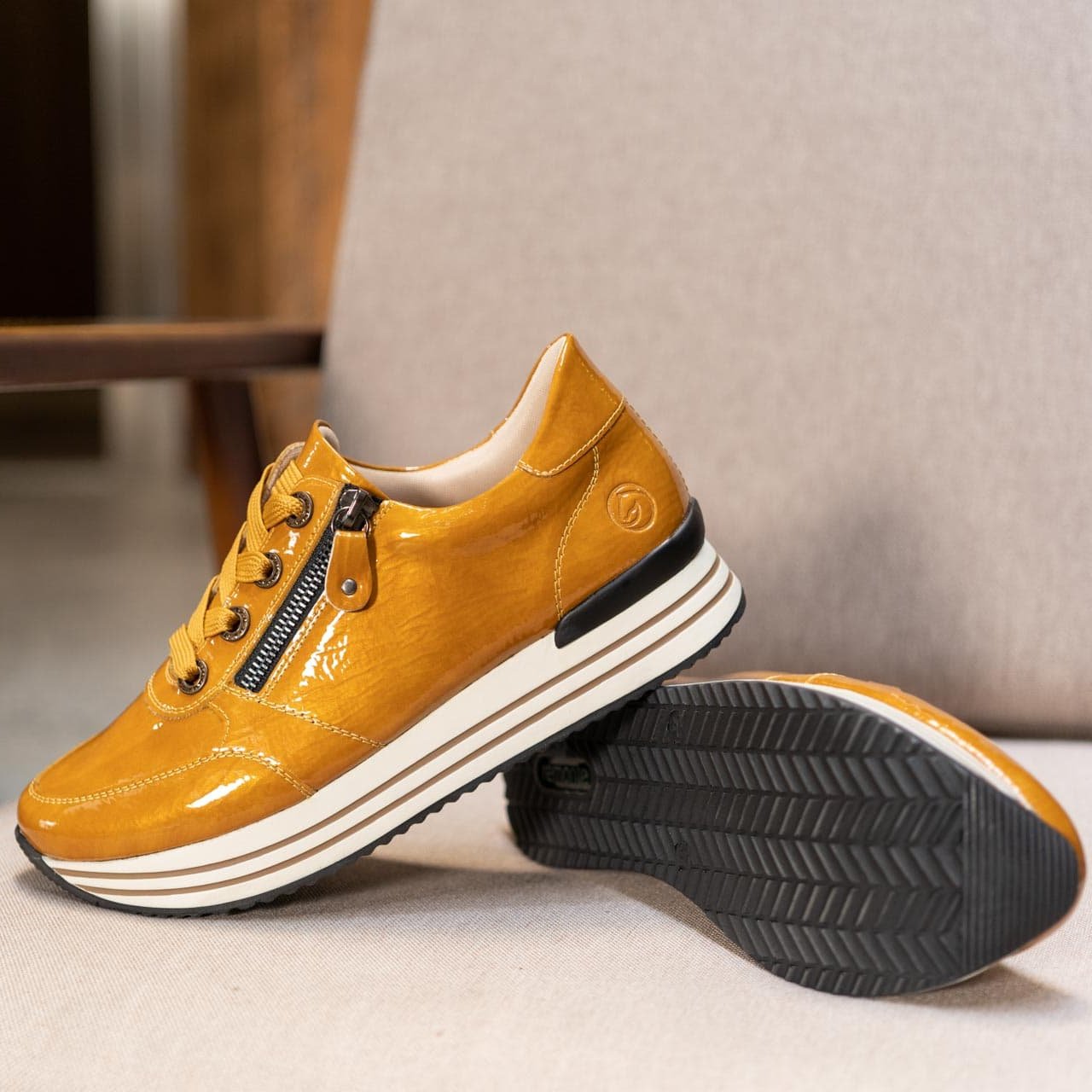 Gelbe Sneaker aus Kunstlack mit Reißverschluss und Schnürung und Wechselfußbett.
