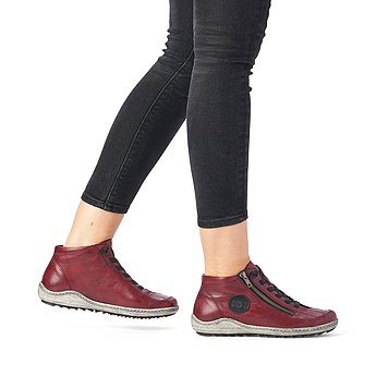 Rote Kurzstiefel aus Glattleder mit Reißverschluss und Schnürung und Wechselfußbett. Schuhe am Fuß.