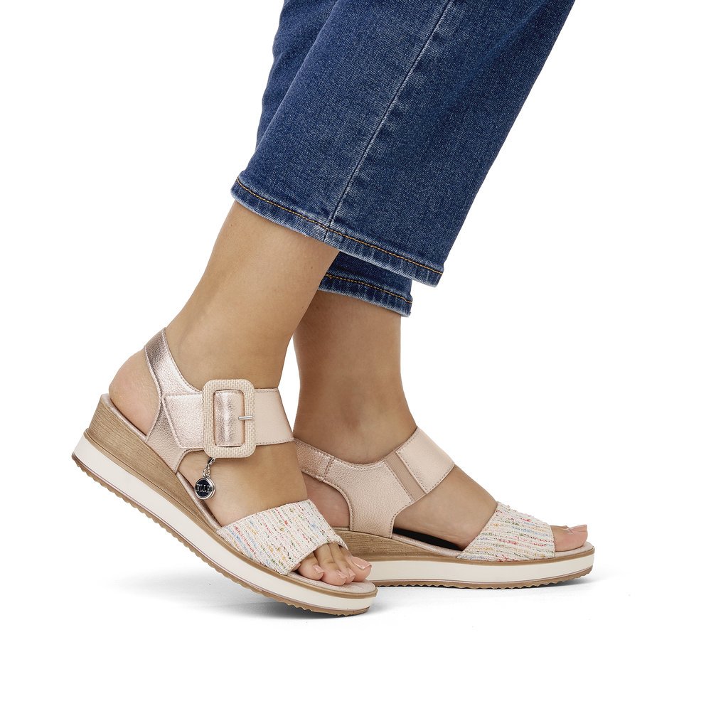 Metallic pink remonte women´s wedge sandals D6453-31 with a hook and loop fastener. Shoe on foot.